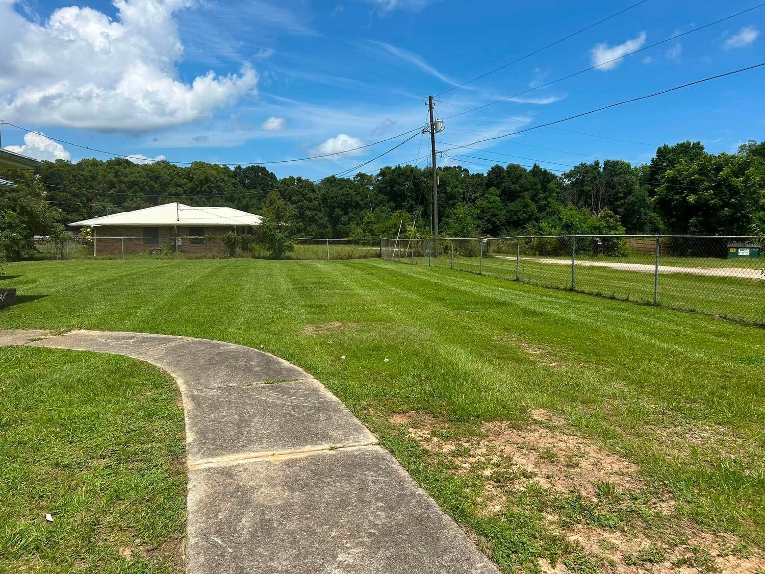 Freshly striped lawn along a fence line